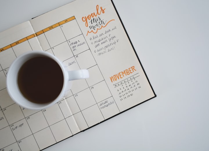 A monthly planner and a cup of coffee